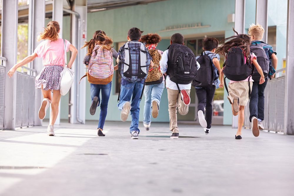 Back to School, Middle school or elementary school kids are running into school with back packs