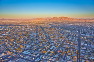 Picture of neighborhoods in Southwest Las Vegas, roof tops to the sunrise over the mountain
