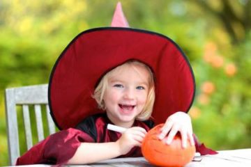 Adorable little girl carving a pumpkin for halloween festivities