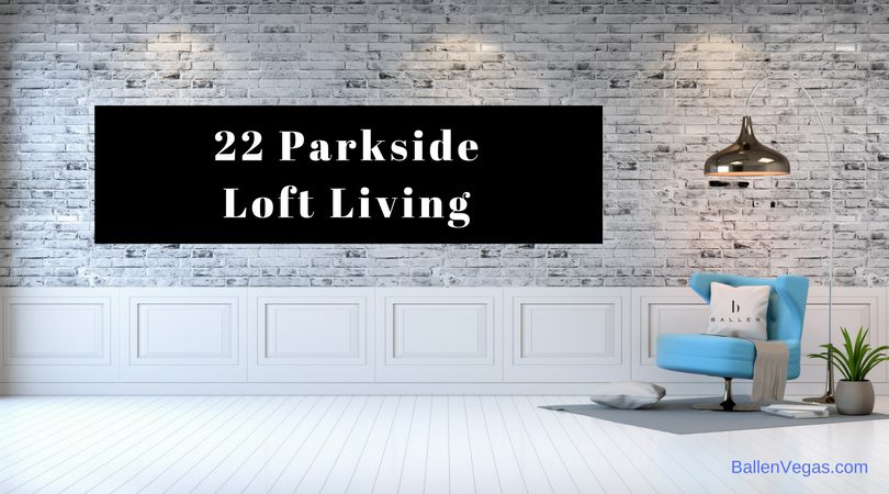 Large room with minimilistic design shows a simple blue chair. Sign reads 22 Parkside Loft Living and has the Ballen Vegas logo
