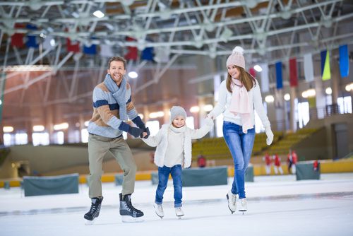 Mom, Dad, Child are skating at what could be the Cosmopolitan Ice skating rink