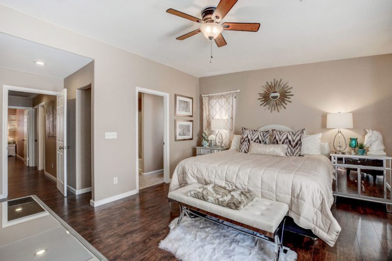 Clean booedroom, ceiling fan, dark flooring, light colored bed, freshly painted walls at 4123 HALFMOON BAY Drive Las Vegas, NV 89115