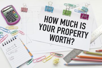 Paper, paperclicks, ruler, postcard that spells out how much is your property worth