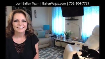 Lori Ballen is making a video on how much is realtor commissions when selling a house in las vegas. She is in her living room and her cat gideon is nearby