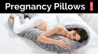 Pregnancy Pillows Guide is on a black banner over a pregnant woman sleeping on her side with a u shaped pregnancy pillow