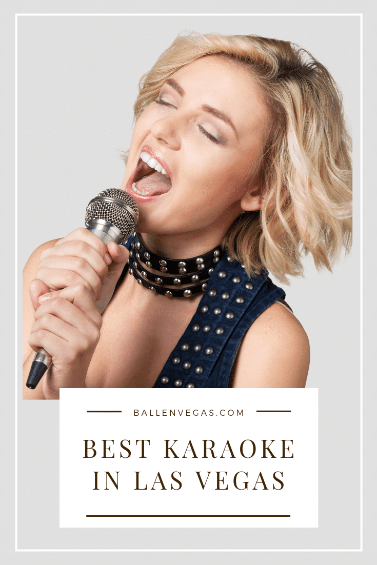 Girl has her mouth open and is singing into a microphone at what looks like karaoke