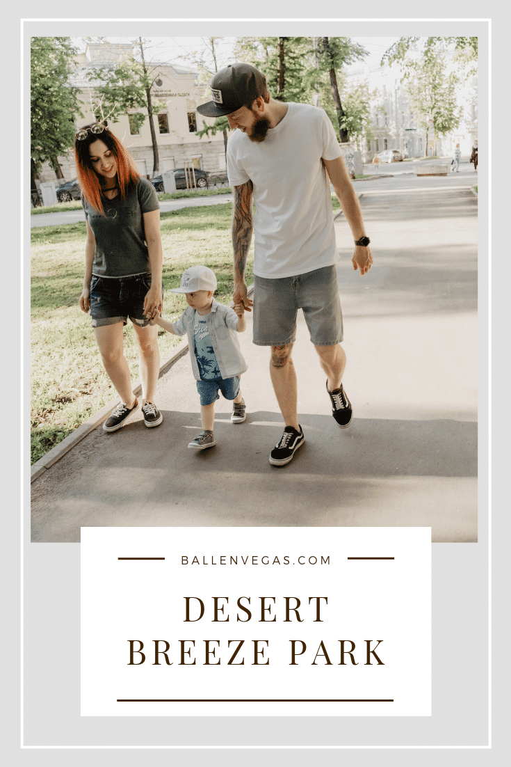 A young couple is walking their child in the park and is part of the Desert Breeze Park Blog Post