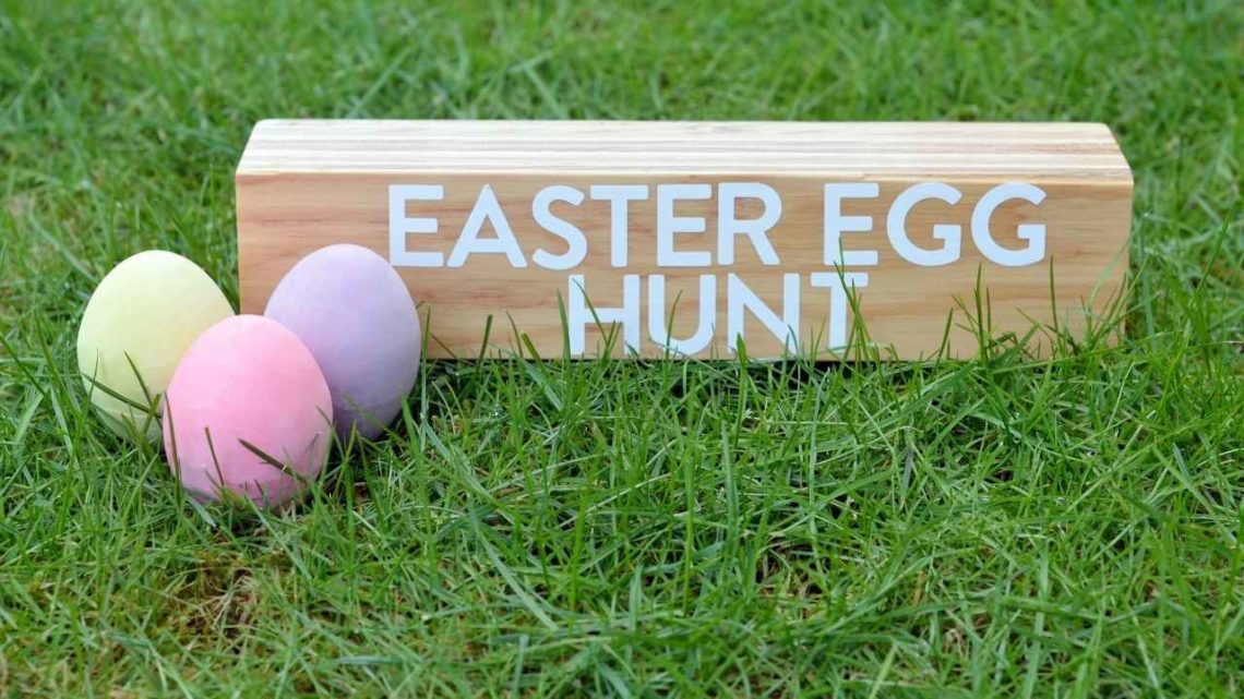 green grass, 3 easter eggs, sign that says easter egg hunt
